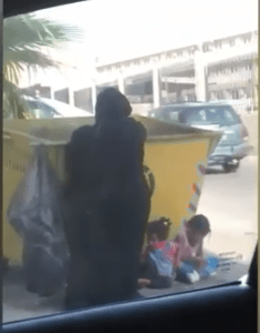 Femme fouillant une poubelle